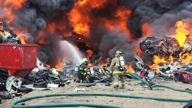 Firefighters battle flames at a tow yard fire in Cahokia Heights Saturday.